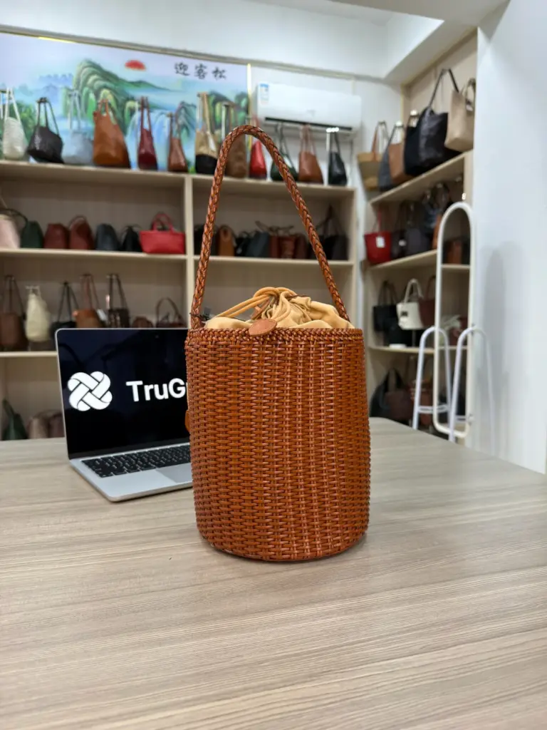 Tan cylindrical woven bag with a braided handle and gathered inner opening (TG-90982)